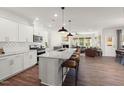 Bright open-concept kitchen featuring a large granite island with bar seating, stainless appliances and an open view to the living room at 716 Ben Ledi Ct, Raleigh, NC 27603