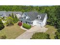 Aerial view of a white two-story home with a gray roof, front porch, garage, and well-maintained landscaping at 72 Cokesbury Park Ln, Fuquay Varina, NC 27526
