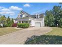 Charming two-story home with a covered front porch, attached garage, and well-manicured landscaping at 72 Cokesbury Park Ln, Fuquay Varina, NC 27526