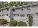 Charming townhouse with gray siding, white picket fence, and a small bench in the front yard at 7383 Sandy Creek Dr, Raleigh, NC 27615
