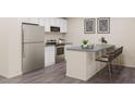 Modern kitchen featuring stainless steel appliances, an island with bar seating, and sleek countertops at 99 Landon Pl, Roxboro, NC 27573