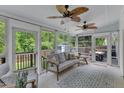 Bright sunroom with multiple windows, ceiling fans, and comfortable seating at 1005 Thorncroft Ln, Apex, NC 27502