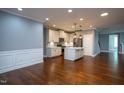 Open-concept kitchen with stainless steel appliances, marble countertops, island, and hardwood floors at 1007 Fairhaven Dr, Mebane, NC 27302