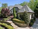 Beautiful front yard with manicured landscaping, stone accents, and a charming walkway at 1009 Linenhall Way, Wake Forest, NC 27587