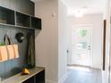 Mudroom area upon entry with a dark built-in shelf, bench, and light-colored flooring at 109 S Plum St, Durham, NC 27703