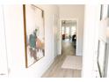 Hallway with a large framed abstract painting, light wood floors, and a view to the living area at 109 S Plum St, Durham, NC 27703