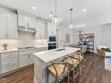 Modern kitchen with stainless steel appliances, a white quartz countertop island, and stylish pendant lighting at 11549 Helmond Way # 103, Raleigh, NC 27617