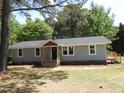 View of the exterior, featuring light blue siding, black door, nice windows, and new wooden decks at 1165 John Mitchell Rd, Youngsville, NC 27596