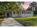 Inviting single-story home with a covered parking area, white brick, and neatly landscaped front yard at 124 Strickland Dr, Smithfield, NC 27577