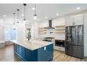 Modern kitchen with stainless steel appliances, a large island, and white subway tile backsplash at 1301 Tawny View Ln, Raleigh, NC 27603