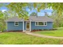 Lovely single-story home with blue brick exterior, manicured lawn, mature trees, and a welcoming front entrance at 1751 Riverside Dr, Hillsborough, NC 27278