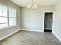 Bright dining room with gray walls, wood floors, and a modern light fixture at 186 Gumtop Dr, Zebulon, NC 27597