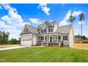 Two-story home with gray siding, black shutters, green lawn, and a walkway to a covered front porch at 186 Gumtop Dr, Zebulon, NC 27597
