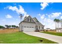 Two-story home featuring gray siding, black shutters, and a well-manicured lawn, framed by mature trees at 186 Gumtop Dr, Zebulon, NC 27597