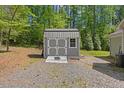 Exterior view of a backyard shed with a gray paint job and double doors at 205 Sacred Fire Rd, Louisburg, NC 27549