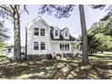 Beautiful two-story house featuring a welcoming porch, classic white siding and mature trees at 2122 Pleasant Hill Rd, Rocky Mount, NC 27801
