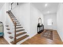 Inviting foyer featuring hardwood floors, staircase, console table with mirror, and access to the upper level at 2749 Nettles Ridge Way, Fuquay Varina, NC 27526