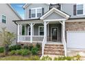 Charming front porch featuring stone stairs, white railing, and a welcoming entrance to the home at 2749 Nettles Ridge Way, Fuquay Varina, NC 27526