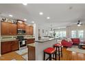 Well-lit kitchen featuring dark wood cabinets, granite countertops, stainless appliances, and an open floor plan at 3009 Weston Green Loop, Cary, NC 27513