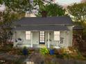 Inviting front of home featuring a cozy porch, rocking chair, and mature landscaping at 310 N Hassel St, Hillsborough, NC 27278