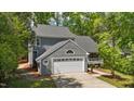 Charming two-story home with attached garage, mature trees, and a concrete driveway at 311 Arlington Ridge Rdg, Cary, NC 27513