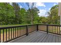 Wooden deck with dark wood railing, offering a view of the surrounding greenery at 326 W Gilbreath St, Graham, NC 27253