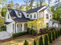 Beautifully landscaped two-story home with white siding, black trim, and a cozy front porch at 3316 Milton Rd, Raleigh, NC 27609