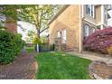 Side yard with a well-manicured lawn, gated access, and mature landscaping at 3517 Elk St, Burlington, NC 27215