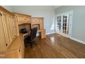Office space featuring hardwood floors, French doors, and custom wooden desk with drawers and cabinets at 4103 Cheek Point Pl, Burlington, NC 27215