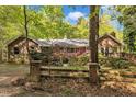 Charming brick home with mature trees, manicured landscaping and wooden fence with brick pillars at 480 Big Branch Dr, Pittsboro, NC 27312