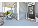 Inviting covered porch featuring comfortable seating and stylish decor, adjacent to the home's entrance at 490 Mallard Loop Dr Dr, Clayton, NC 27527