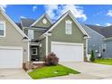 Charming home featuring a two-car garage, well-manicured lawn, and inviting curb appeal at 518 Judge Ct, Durham, NC 27703