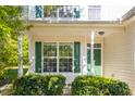 Inviting front porch with green shutters and matching door complemented by lush greenery and manicured bushes at 6 Dawson Ct Ct, Durham, NC 27703