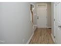 Clean, bright foyer with wood-look flooring, neutral walls, and a view of the staircase at 6022 Four Townes Lane Ln, Raleigh, NC 27616