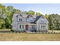 Charming two-story home with a manicured lawn and covered porch, surrounded by lush trees at 67 Farmstead Ct, Wendell, NC 27591