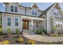 Inviting front entrance with a double wooden door, stone steps, metal railing and manicured landscaping at 67 Farmstead Ct, Wendell, NC 27591