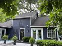 Attractive home exterior with blue siding, white trim, decorative accents, complemented by lush landscaping and a cozy outdoor seating area at 6765 Rock Service Station Rd Rd, Raleigh, NC 27603