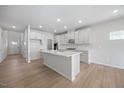 Modern kitchen with gray cabinets, a central island, stainless steel appliances, and hardwood floors at 708 Deschutes Dr, Garner, NC 27529