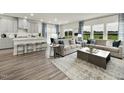 Spacious living room with hardwood floors, a kitchen island, comfortable seating, and natural light at 708 Deschutes Dr, Garner, NC 27529