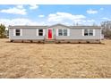 Inviting single-story home with a red door, gray siding, and a spacious front yard at 7289 Nc 561, Louisburg, NC 27549