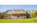 Inviting two-story brick home with a covered front porch and manicured lawn at 7371 Leasburg Rd, Roxboro, NC 27574
