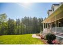 Landscaped front yard leading to a charming brick home with a welcoming porch at 7371 Leasburg Rd, Roxboro, NC 27574