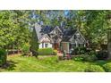 Attractive home with stone accents, arched window, tidy landscaping, and a lush green lawn at 5113 Windance Pl, Holly Springs, NC 27540