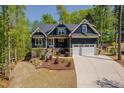 Charming exterior showcasing meticulous landscaping, stone accents, and a two-car garage at 104 Blue Finch Ct, Youngsville, NC 27596