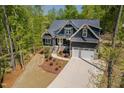 Stunning home exterior with lush greenery, a stone foundation, and an extended driveway at 104 Blue Finch Ct, Youngsville, NC 27596