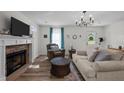 Inviting living room with a stone fireplace, plush seating, and a view of the front door, radiating warmth and comfort at 108 Ruff Davis Rd, Roxboro, NC 27574