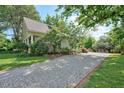 Gravel driveway leading to the house and backyard featuring mature trees and landscaping at 109 N Hassel St, Hillsborough, NC 27278