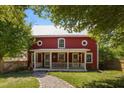 Quaint red home featuring a welcoming front porch and a stone walkway at 109 N Hassel St, Hillsborough, NC 27278