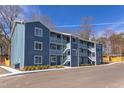 Three-story apartment building showcasing blue siding, walkways, stairs, and manicured landscaping at 1309 Hudson Ave # D1, Durham, NC 27705