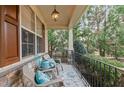Inviting covered front porch featuring comfortable seating, stone accents, and outdoor lighting at 1320 Heritage Hills Way, Wake Forest, NC 27587